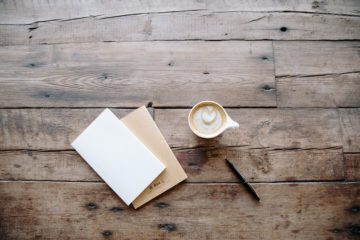 Une table avec un café, un carnet et un stylo